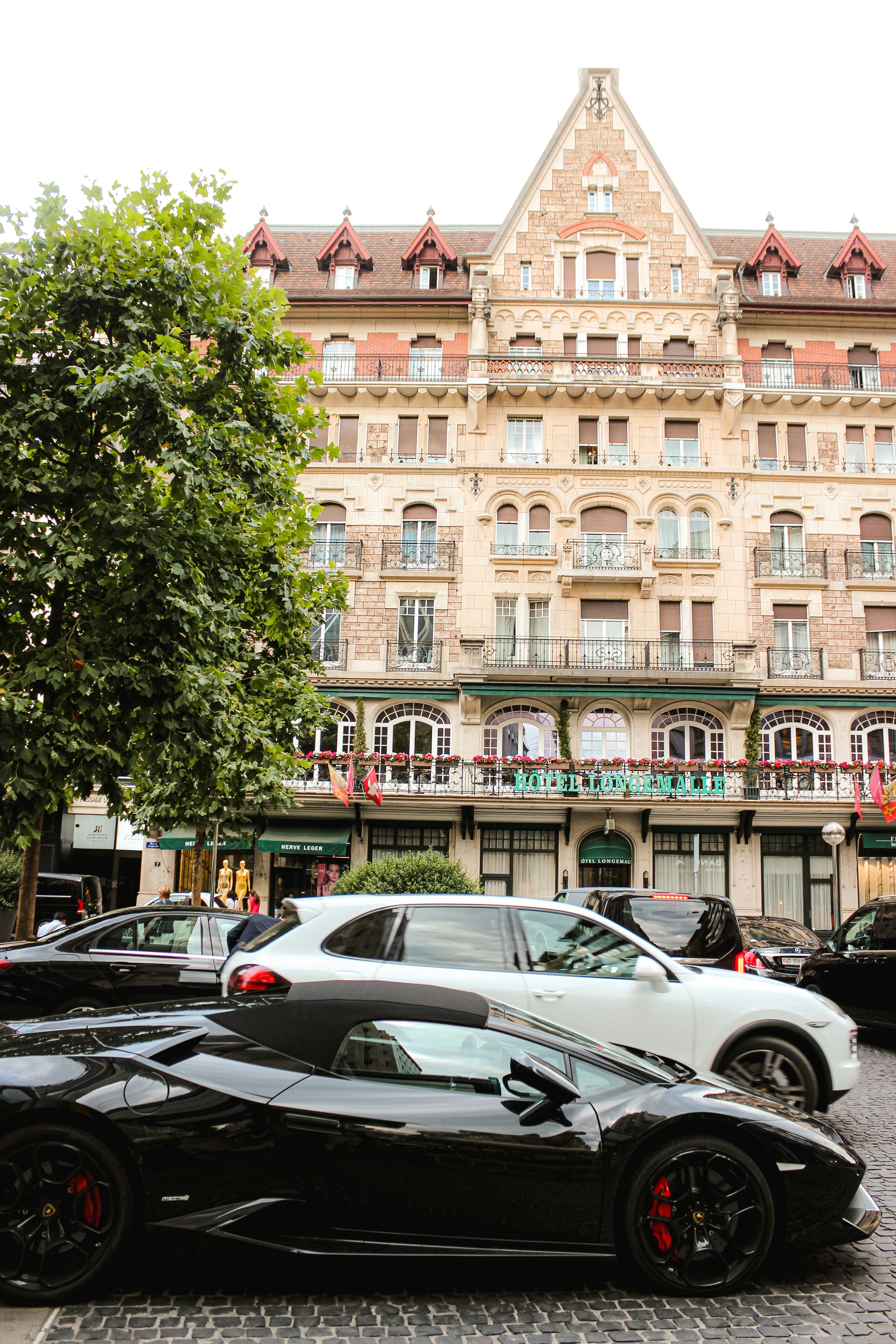 cars parked in front of brown building